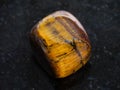 polished tiger-eye gem stone on dark background Royalty Free Stock Photo