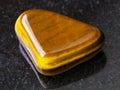 polished tiger-eye gem stone on dark background Royalty Free Stock Photo