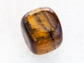 polished tiger-eye gem stone on white marble Royalty Free Stock Photo