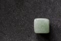 Polished tumbled green aventurine stone on a black background