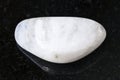 polished white moonstone (adularia) gem on dark