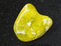 polished yellow Lizardite gemstone on dark