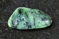 polished zoisite gemstone on dark background