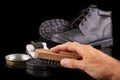 Polishing and cleaning leather shoes with a brush. Cleaning work shoes. Royalty Free Stock Photo