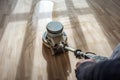 Polishing wooden parquet floor with special orbital machine Royalty Free Stock Photo