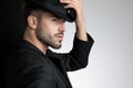 Polite smart casual man holding black hat in studio