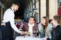 polite waiter serving guests at terrace restaurant Royalty Free Stock Photo