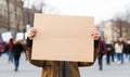 A political activist protesting holding a blank placard sign banner at a protest