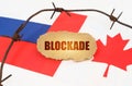 On the flags of Canada and Russia lies a cardboard plate with the inscription - Blockade