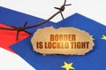 On the flags of the European Union and Russia lies a cardboard plate with the inscription - Border is locked tight Royalty Free Stock Photo