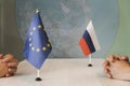 Political flags of russia and European Union on table in international negotiation room. concept of negotiations, collaboration