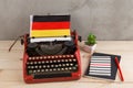Political, news and education concept - red typewriter, flag of the Germany and notebooks