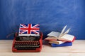 Political, news and education concept - red typewriter, flag of the United Kingdom, books on table