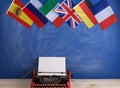 Political, news and education concept - red typewriter, flags of Spain, France, Great Britain and other countries