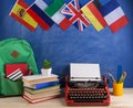 Political, news and education concept - red typewriter, flags of Spain, France, Great Britain and other countries, backpack, books