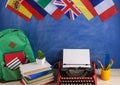 Political, news and education concept - red typewriter, flags of Spain, France, Great Britain and other countries, backpack, books