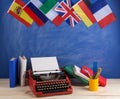 Political, news and education concept - red typewriter, flags of Spain, France, Great Britain and other countries, books,