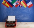 Political, news and education concept - red typewriter, flags of Spain, France, Great Britain and other countries