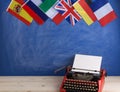 Political, news and education concept - red typewriter, flags of Spain, France, Great Britain and other countries