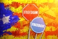 Political slogan FREEDOM in the form of traffic signs with Flag of Catalonia on the background