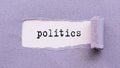 POLITICS text on white background under torn violet paper layer