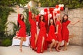 Polka dot birthday party. Group of female friends enjoying and laughing. Women in dresses having fun by Photo zone from red and