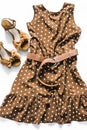 Polka dot brown sleeveless summer dress and suede wedge sandals on a light background, top view. Fashion concept Royalty Free Stock Photo