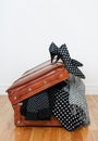 Polka dot clothing in a vintage leather suitcase Royalty Free Stock Photo