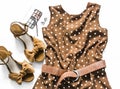 Polka dot summer brown dress, suede wedge sandals, cosmetics on a light background, top view. Women`s clothing set Royalty Free Stock Photo