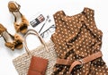 Polka dot summer brown dress, suede wedge sandals, eco straw tote bag, cosmetics on a light background, top view. Women`s clothin Royalty Free Stock Photo