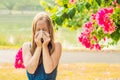 Pollen allergy concept. Young woman is going to sneeze. Flowering trees in background Royalty Free Stock Photo