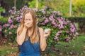 Pollen allergy concept. Young woman is going to sneeze. Flowering trees in background Royalty Free Stock Photo