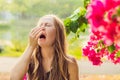 Pollen allergy concept. Young woman is going to sneeze. Flowering trees in background Royalty Free Stock Photo