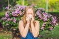 Pollen allergy concept. Young woman is going to sneeze. Flowering trees in background Royalty Free Stock Photo