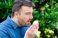 Pollen allergy in springtime concept. Man sneezing in a tissue Royalty Free Stock Photo