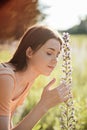 Pollen season. Summer allergies are caused by pollen from grass and Flowers. Young woman smells the blooming Flowers