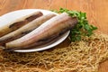 Pollock carcasses on rustic table with parsley and fishing net