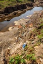 Polluted Garbage and Trash in a River Bank Royalty Free Stock Photo