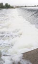 Polluted river full of foam at diversion dam