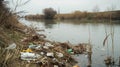 Polluted river with plastic bottles and trash under cloudy skies, highlighting environmental impact and need for Royalty Free Stock Photo