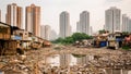 A polluted slum area contrasts with high-rise buildings in a cityscape.