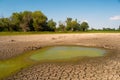 Polluted Water And Cracked Soil Of Dried Out Lake During Drought