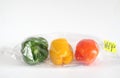 polluting plastic wrapped food concept, bell peppers in a plastic bag, sign with caption environmental conservation Royalty Free Stock Photo