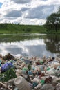 Pollution of the lake, fresh water. Plastic trash, dirty waste on the beach on a summer day. beautiful nature and peoplelessness.