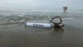 Pollution message inside the glass bottle dragged by the abandoned tide on the beach Royalty Free Stock Photo