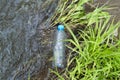 Pollution of nature, ecoclogy concept. Plastic bottle floating in water, top view. Discarded plastic waste in a stream lake Royalty Free Stock Photo