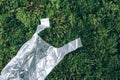Pollution problem concept. Disposable plastic bag on green moss, grass background. Top view. Copy space. Environmental Royalty Free Stock Photo