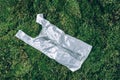Pollution problem concept. Disposable plastic bag on green moss, grass background. Top view. Copy space. Environmental Royalty Free Stock Photo