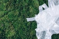 Pollution problem concept. Disposable plastic bags on green moss, grass background. Top view. Copy space. Environmental Royalty Free Stock Photo