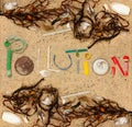 Pollution text made from real single use plastic rubbish found on beach with shells, seaweed and natural beach debris